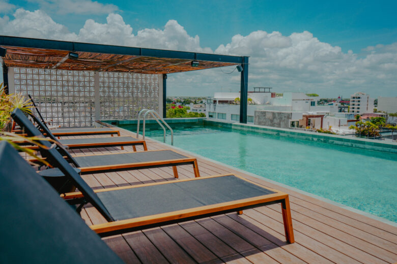 La alberca de Macondo Quinta Avenida Fase 2 se encuentra en el rooftop, con una espectacular vista al mar Caribe. Rodeada de terrazas, camastros y vegetación tropical, ofrece un ambiente de descanso y exclusividad en el corazón de Playa del Carmen, dentro de un desarrollo con departamentos en venta en Playa del Carmen que combinan lujo y confort.