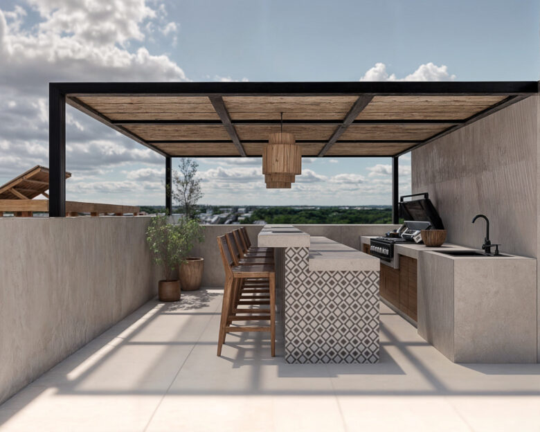 Rooftop del desarrollo Macondo Punta Esmeralda con barra de concreto decorativo, sillas altas de madera, parrilla y fregadero, bajo una pérgola moderna con vista panorámica, dentro de los departamentos en venta en Playa del Carmen.