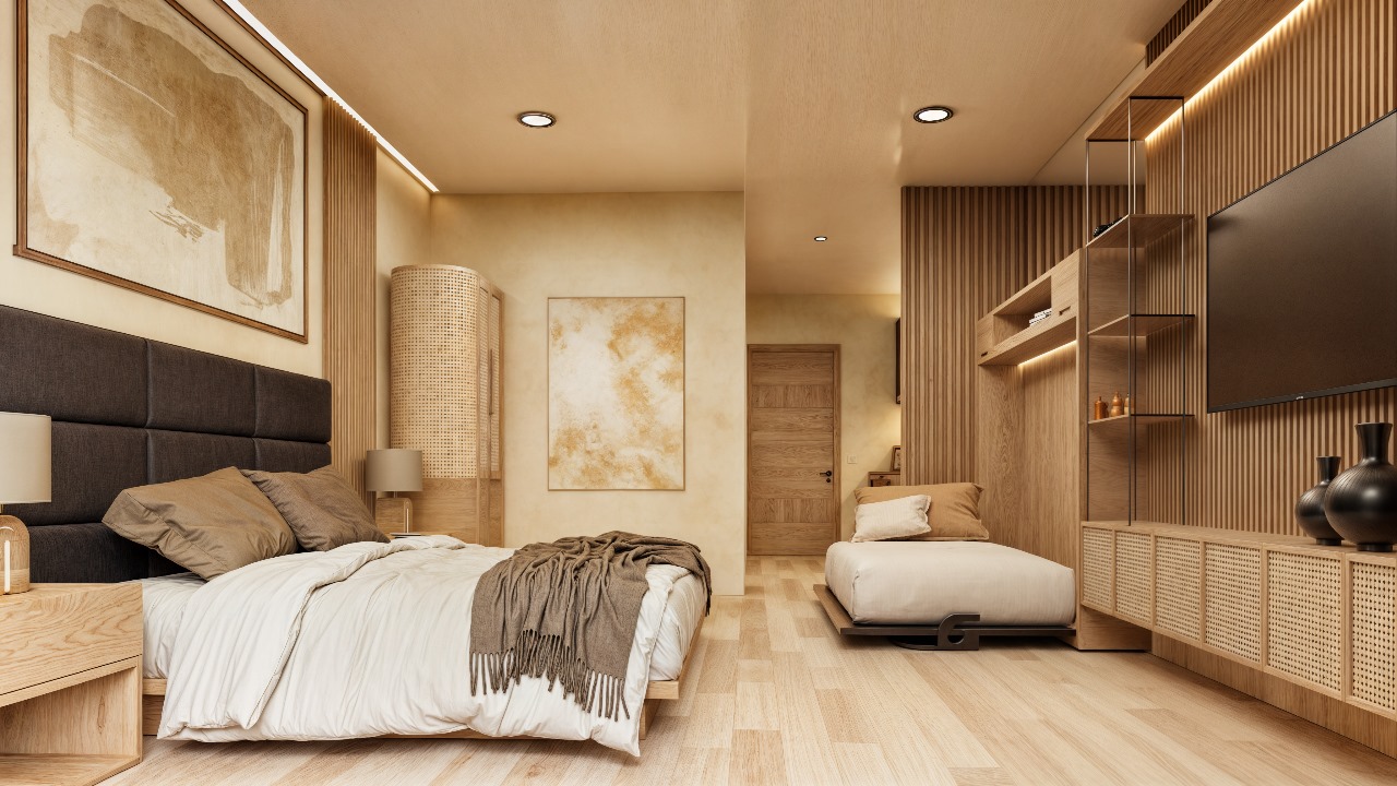Interior de unidad en Macondo Corazón con cama abatible (Murphy), mobiliario de madera natural, iluminación cálida, arte contemporáneo en tonos neutros y ventanal hacia la terraza. Espacio moderno y versátil dentro de los departamentos en venta en Playa del Carmen.