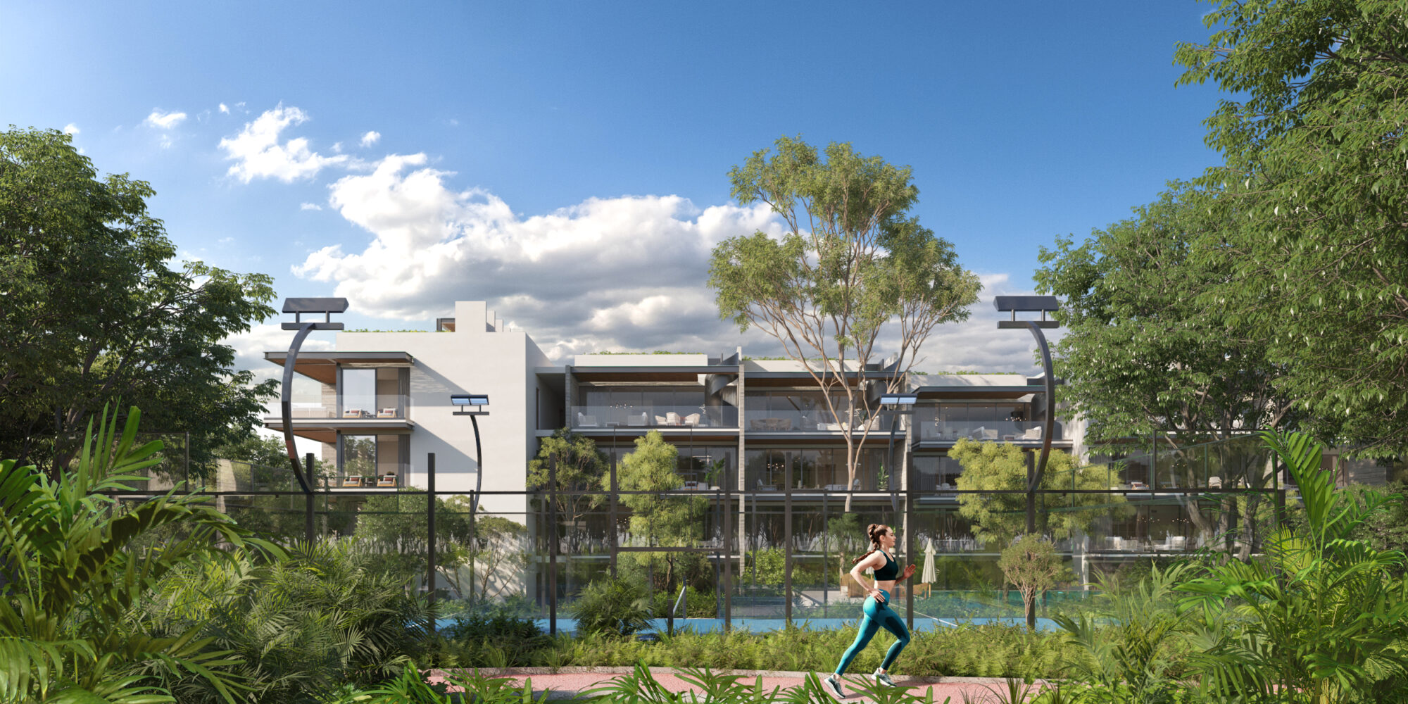 Cancha de pádel en Macondo Playacar rodeada de vegetación tropical, con luminarias modernas, superficie profesional y vista a los edificios residenciales contemporáneos; una persona corriendo por un sendero junto al área deportiva. Parte de las amenidades exclusivas de los departamentos en venta en Playa del Carmen dentro del desarrollo.